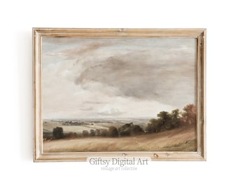 May include: A framed painting depicting a landscape with a cloudy sky, rolling hills, and a distant town. The painting is in a light wood frame.