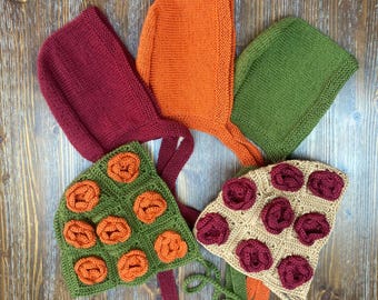 May include: Five knitted hats in different colours and patterns. The hats are made of wool and have a variety of floral designs. The hats are arranged in a circle on a wooden surface.