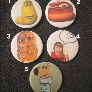 May include: Five round buttons with different cartoon characters. The buttons are white with a black border. The characters are a yellow worm, a red worm, a fried chicken nugget, a man with a speech bubble, and a cartoon dog.