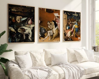 Pode incluir: Três impressões de arte emolduradas de pinturas surrealistas de Hieronymus Bosch. As pinturas estão em uma sala de estar com um sofá branco e almofadas.