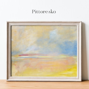 May include: An abstract landscape painting in a white framed canvas. The artwork features a blend of yellow, blue, and pink hues, evoking a serene atmosphere. The word "Pittoresko" is printed at the top of the image.