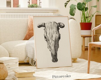 Puede incluir: Una ilustración en blanco y negro de un cráneo de vaca con cuernos. La ilustración está sobre un fondo crema y enmarcada en un marco de madera claro. La imagen está colgada en una pared en un salón.