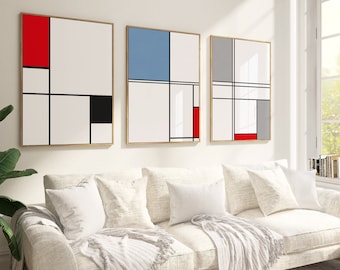 May include: Three abstract geometric paintings in wooden frames, with a red, blue, and grey colour scheme. The paintings are hung on a white wall above a white sofa.