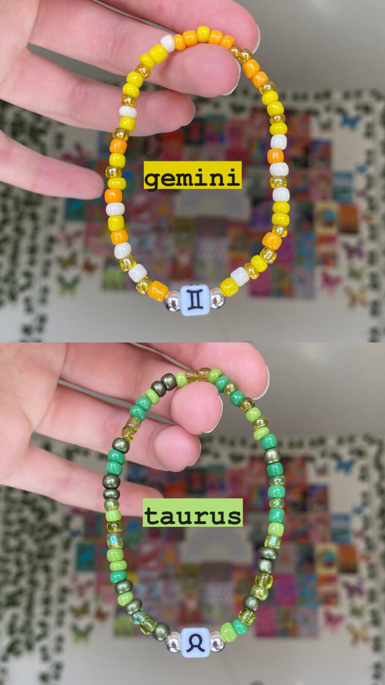 May include: Two beaded bracelets. The top bracelet is yellow, orange, and white with a Gemini symbol. The bottom bracelet is green with a Taurus symbol. Both bracelets are on a white background.