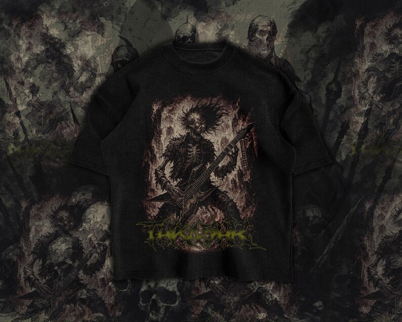 May include: Black t-shirt featuring a skeletal figure playing a guitar, with a fiery background. The design includes the text "THE ABYSS" in green. The shirt has a vintage, distressed look, with a crew neck and short sleeves.