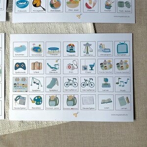 May include: A visual schedule with colorful illustrations of activities for children. The schedule includes activities like swimming, playing on a playground, riding a bike, and learning. The text on the schedule includes words like "Schwimmen", "Spielplatz", "Fahrradfahren", and "Lernen".