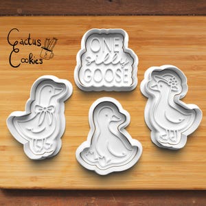 Può includere: Quattro formine per biscotti in plastica bianca a forma di oche e la frase "ONE silly GOOSE". Un'oca ha un fiocco, un'altra un cappello con fiori. Il logo "Cactus Cookies" si trova nell'angolo in alto a sinistra.