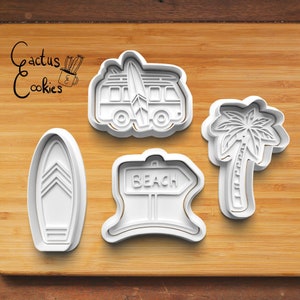 Könnte beinhalten: Vier weiße Plastik-Ausstecher in Form eines Surfbretts, einer Palme, eines Vans mit einem Surfbrett auf dem Dach und eines Schilds mit der Aufschrift "Beach".