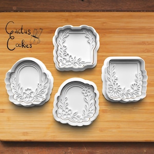 Könnte beinhalten: Vier weiße Ausstecher mit floralen und Blattmustern. Die Ausstecher haben verschiedene Formen, darunter ein Quadrat, ein Rechteck und zwei bogenförmige Formen. Der Text "Cactus Cookies" befindet sich in der oberen linken Ecke.