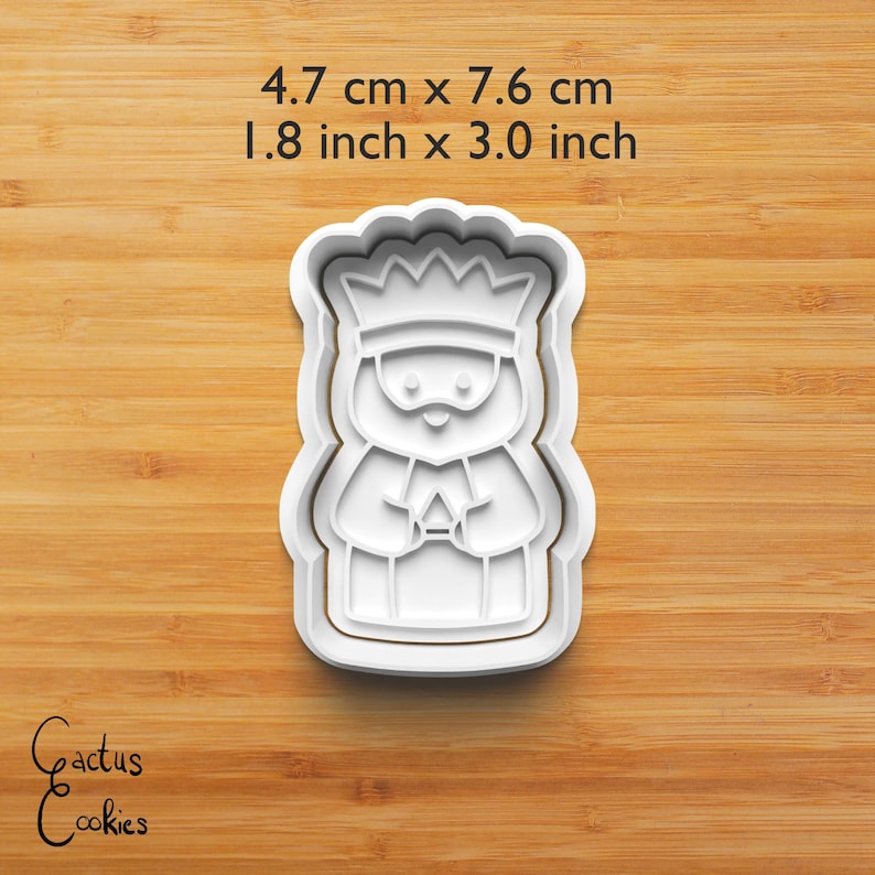 Puede incluir: Cortador de galletas de pl&aacute;stico blanco con forma de rey, de 4,7 cm por 7,6 cm (1,8 pulgadas por 3,0 pulgadas). El rey lleva una corona y sostiene un regalo. El texto "4.7 cm x 7.6 cm" y "1.8 inch x 3.0 inch" est&aacute; encima. Las palabras "Cactus Cookies" est&aacute;n en la esquina inferior izquierda.