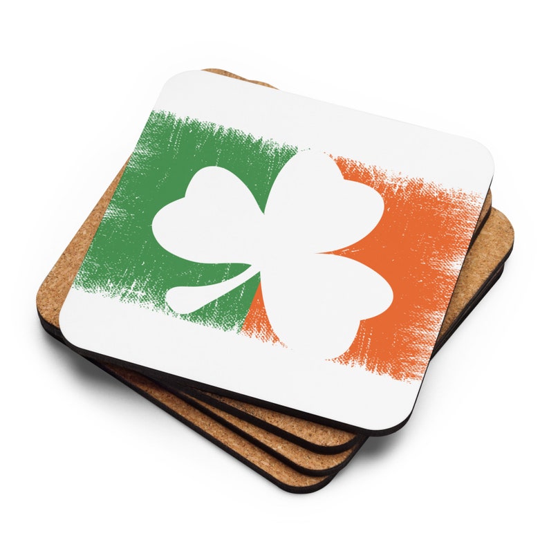 May include: Set of four cork-backed coasters featuring a white shamrock on a green and orange background.