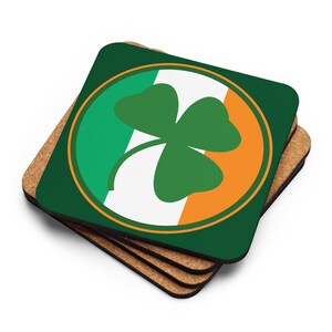 May include: Set of four green cork coasters with a circular design featuring a shamrock and the Irish flag colors of green, white, and orange.