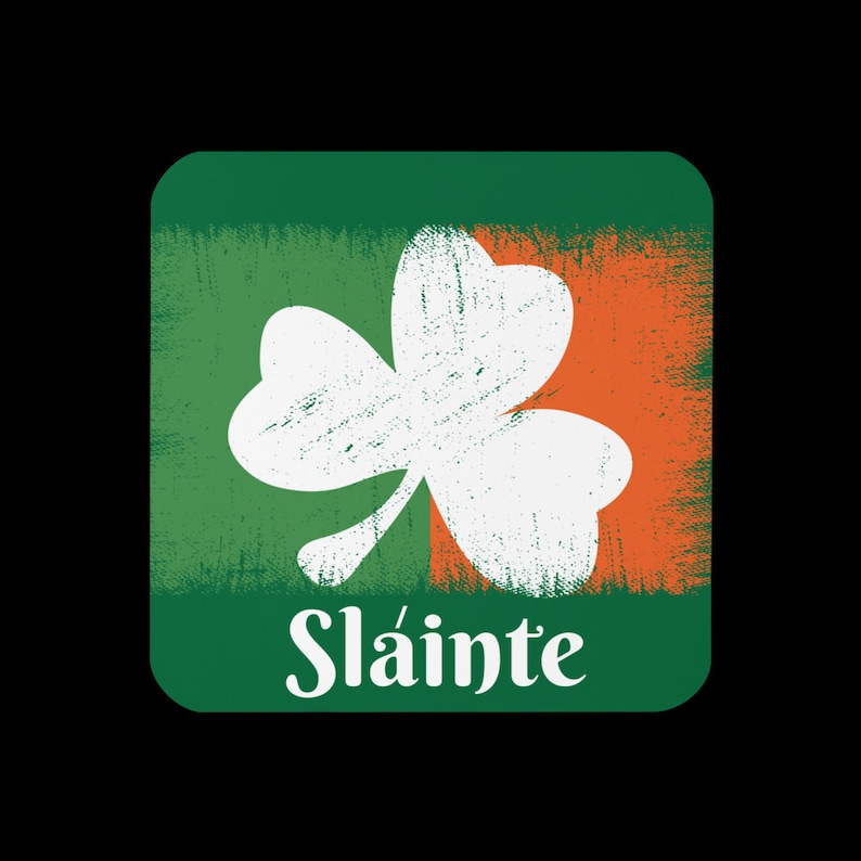 Puede incluir: Un cuadrado verde y naranja con un tr&eacute;bol blanco y la palabra "Sl&aacute;inte" en blanco.