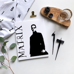 May include: A black and white illustration of a person with the word "MATRIX" printed vertically on the left side of the image.