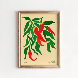 Op de afbeelding: Een ingelijste illustratie van rode pepers met groene bladeren op een cr&egrave;mekleurige achtergrond. De tekst "with capsicum" staat onderaan de afbeelding.