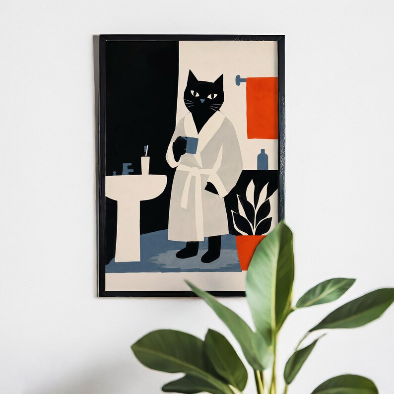 Puede incluir: Una impresi&oacute;n art&iacute;stica enmarcada representa un gato negro con una bata blanca sosteniendo una taza azul en un ba&ntilde;o. El ba&ntilde;o tiene un lavabo blanco, una toalla naranja y una planta en maceta. El fondo est&aacute; dividido en secciones negras y crema.