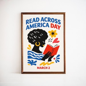 May include: A framed poster with the text "READ ACROSS AMERICA DAY" in blue and red. The illustration features a silhouette of a person with black hair and gold earrings reading a red book, with decorative flowers and hearts.