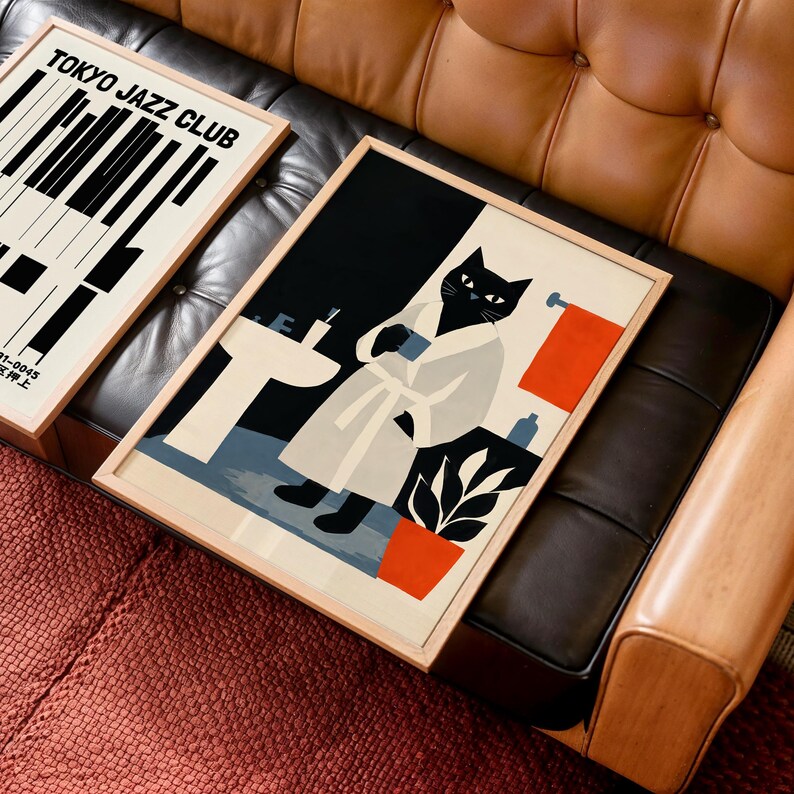 Puede incluir: Dos l&aacute;minas art&iacute;sticas enmarcadas. Una presenta un dise&ntilde;o de teclado de piano con el texto "TOKYO JAZZ CLUB". La otra l&aacute;mina representa un gato negro con una bata blanca en un ba&ntilde;o. Las l&aacute;minas est&aacute;n enmarcadas en madera.
