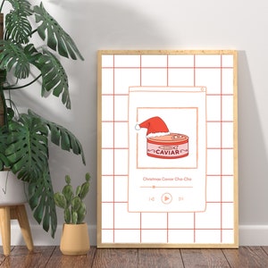 Könnte beinhalten: Ein Bildschirm eines digitalen Musikplayers mit einer roten und weißen Illustration einer Kaviar-Dose, die einen Weihnachtsmann-Hut trägt. Unter der Illustration steht der Text "Christmas Caviar Cha-Cha". Auf dem Bildschirm sind Play-, Pause- und Skip-Buttons sichtbar.