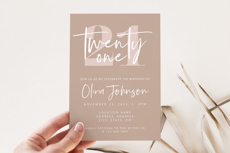 May include: A light brown invitation card with white text. The text says "twenty one" in a large, stylized font. The invitation is for Olivia Johnson's 21st birthday party on November 25, 2022. The invitation includes the time, location, and contact information.