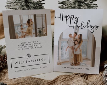 May include: A Christmas card with a photo of a family of four in front of a window. The card is beige with a white border and the text "Happy Holidays" in black cursive. The text "The Williamsons | 2022" is printed in black at the bottom of the card.