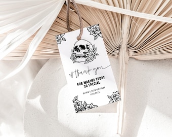 Puede incluir: Una etiqueta de regalo rectangular blanca con un cordel marrón, que presenta una ilustración en tinta negra de una calavera rodeada de rosas. El texto dice: Thank you, FOR MAKING TODAY SO SPECIAL, OLIVIA'S 30TH BIRTHDAY, 11.25.2023.