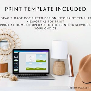 May include: A laptop computer screen displaying a design template with the text "Thank You" and a green and blue landscape. The laptop is on a white desk with a brown hat, a lamp, and a wooden bowl with white beads.