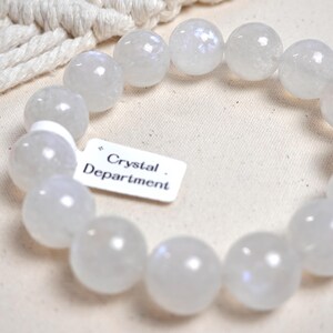 May include: A white gemstone bracelet with a tag that reads "Crystal Department".