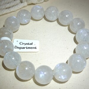 May include: A white crystal bracelet with a frosted finish. The bracelet is made of round beads and is approximately 18 inches in length.