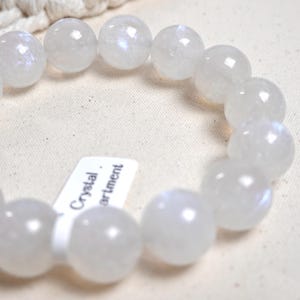 May include: A white gemstone bracelet with a tag that reads "Crystal Department".