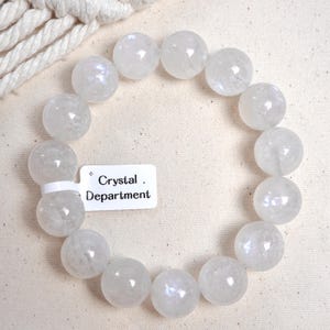 May include: A white crystal bracelet with a tag that reads "Crystal Department".