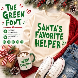 May include: A cream-colored crewneck sweatshirt featuring the green text "SANTA'S FAVORITE HELPER" with a small heart. The design is displayed alongside a white mug with "MERRY CHRISTMAS" in green, a gift box with a red and white striped ribbon, and white sneakers.