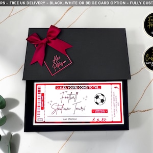 May include: A black gift box with a dark red ribbon and a matching gift tag labeled Alex Peterson. Inside, a white and red ticket features the text Alex, you're going to the Football Stadium Tour, a soccer ball graphic, and a scratch-off panel.