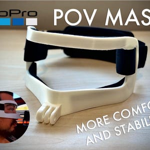 May include: White and black POV mask with the GoPro logo. The mask has a curved design with black padding and the text "POV MASK" and "MORE COMFORT AND STABILITY!"