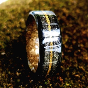 Carbon fiber ring with nurburgring medal shavings from 1969, 24k Alaska BC panned gold, Brenham pallasite meteorite shavings