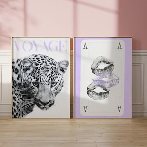 Może przedstawiać: Dwa oprawione wydruki artystyczne. Lewy wydruk przedstawia czarno-białego lamparta ze słowem "VOYAGE" w kolorze lawendy. Prawy wydruk to karta do gry ze stosami ust i literą "A" w każdym rogu.