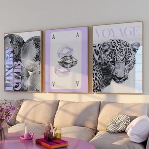 May include: Three framed wall art pieces. The first features disco balls with the word "LUXURY" in lavender. The second shows a playing card with lip prints. The third displays a leopard with the word "VOYAGE".