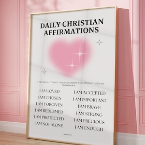 Puede incluir: Un cartel enmarcado con el texto "Daily Christian Affirmations". Presenta una lista de afirmaciones como "Soy amado" y "Soy elegido". Un corazón rosa en el centro, en un marco dorado.