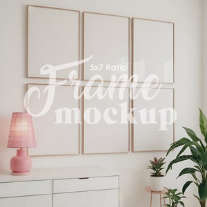 Puede incluir: Seis marcos de fotos dorados con paspartús blancos están dispuestos en una cuadrícula en una pared blanca. Los marcos están vacíos y listos para fotos u obras de arte. Los marcos están en una proporción de 5x7. Hay una lámpara rosa sobre una cómoda blanca y una planta verde en una maceta blanca sobre un soporte dorado.