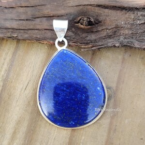 May include: A teardrop-shaped pendant made of silver with a large, deep blue lapis lazuli stone.