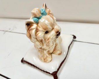 陶器製のヨークシャーテリアの置物：枕の上にいる釉薬をかけた子犬