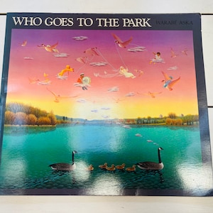 May include: A children's book titled "WHO GOES TO THE PARK" by Warabé Aska. The cover art depicts a vibrant scene with geese, ducklings, and figures flying kites over a lake at sunset. The sky transitions from purple to orange.