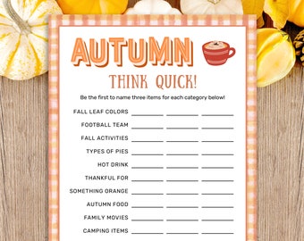 May include: A printed game sheet titled AUTUMN THINK QUICK! featuring a red mug illustration. The text reads: Be the first to name three items for each category below! Categories include Fall Leaf Colours, Football Team, Fall Activities, Types of Pies, Hot Drink, Thankful For, Something Orange, Autumn Food, Family Movies, and Camping Items.