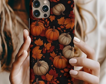 May include: A black phone case with a fall-themed design featuring orange and brown pumpkins and red and orange leaves.