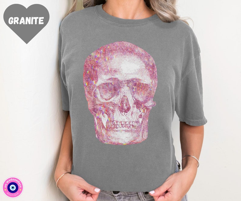 Op de afbeelding: Een grijs T-shirt met een roze glitter schedel print.