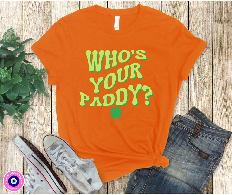 May include: Orange t-shirt with the text "Who's Your Paddy?" in green and yellow letters. A green shamrock is below the text.