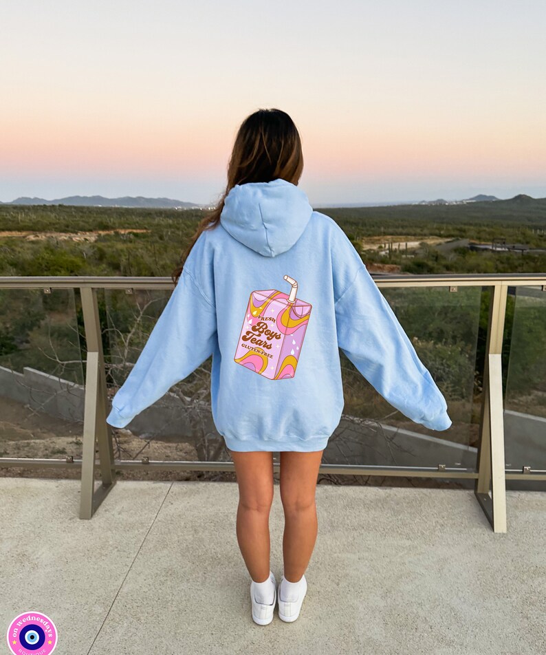 May include: A light blue hoodie with a graphic of a pink juice box on the back. The juice box has a straw and says "Fresh Boys Tears Gluten Free" on it.