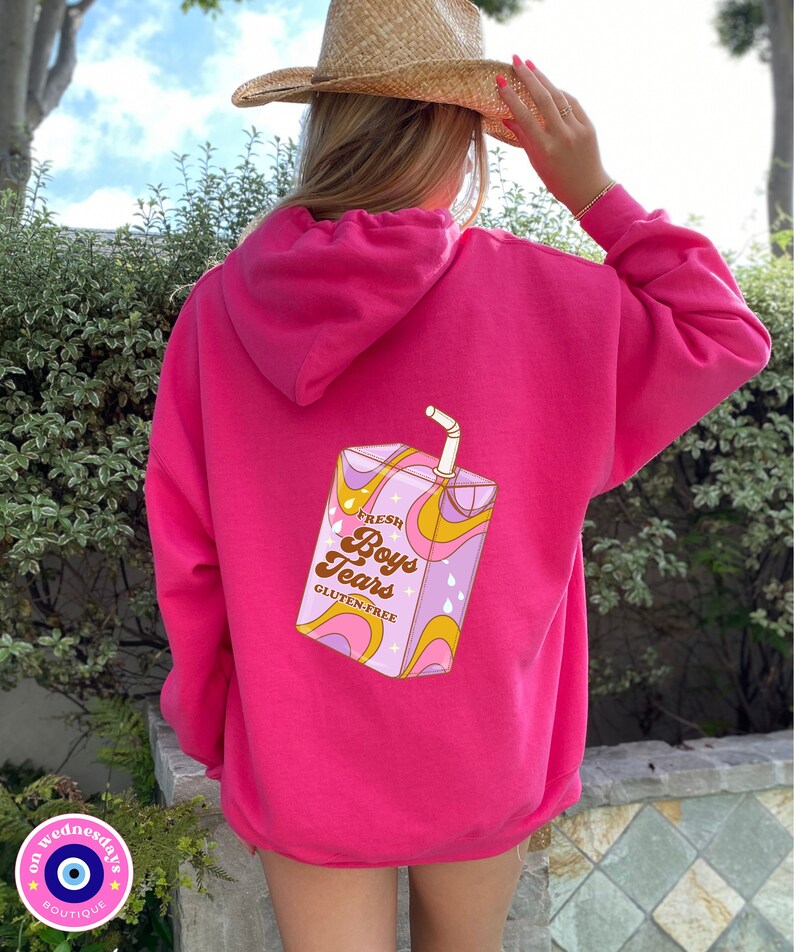 May include: Pink hoodie with a graphic of a cartoon juice box that says "Fresh Boys Tears Gluten-Free" on it.