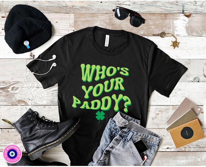 May include: Black t-shirt with a green graphic that says "Who's Your Paddy?" with a green four-leaf clover.