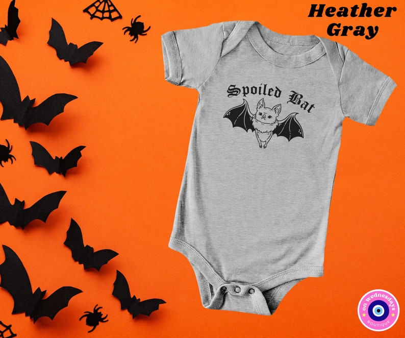 May include: A heather gray baby onesie with a black and white illustration of a bat with the text "Spoiled Bat" in a gothic font.